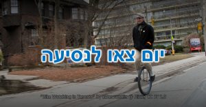 יום צאו לנסיעה: אדם חייכן רוכב על חד אופן